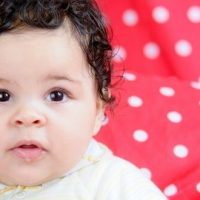 cute baby girl on red and white polka dot background